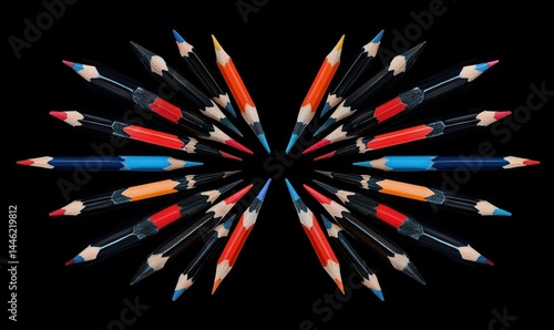 Obraz na płótnie Set of colored pencils neatly arranged on a black background, their sharp tips pointing inwards to create symmetry. w salonie