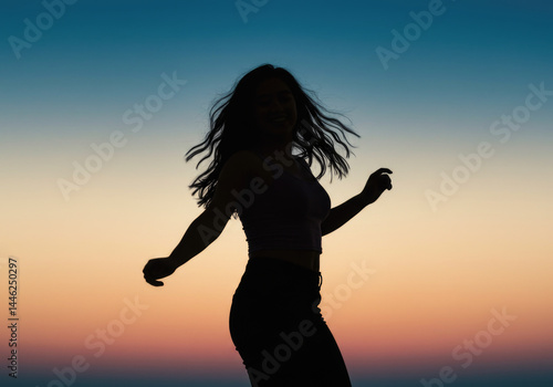 Silhouette of young asian female dancing at sunset