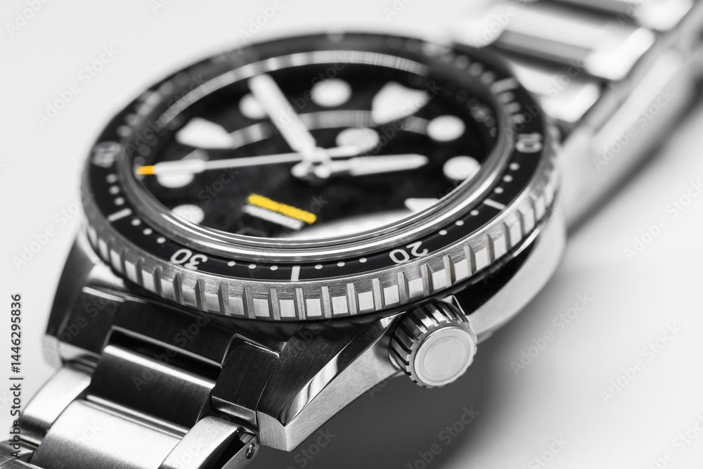 Macro image highlighting a luxury black wristwatch featuring a stainless steel casing, precision details, and a diver styled bezel