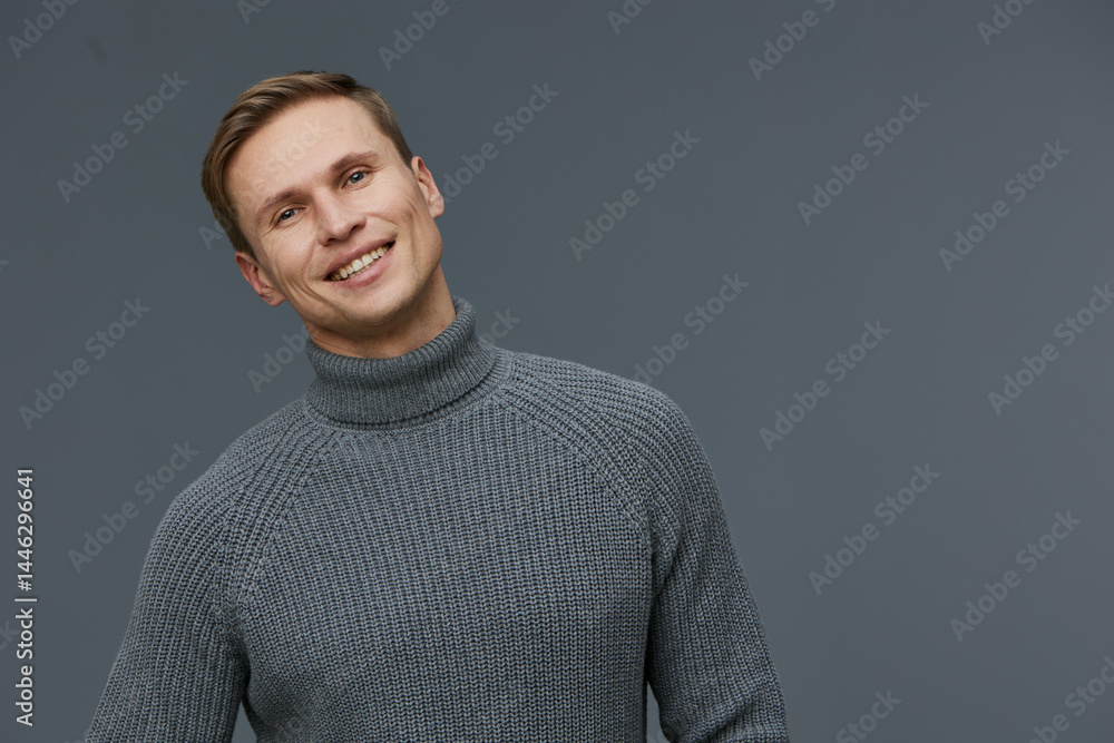 Casual portrait of smiling man in gray turtleneck sweater looking at camera isolated on gray background with friendly expression, daytime, studio shot, people lifestyle concept.