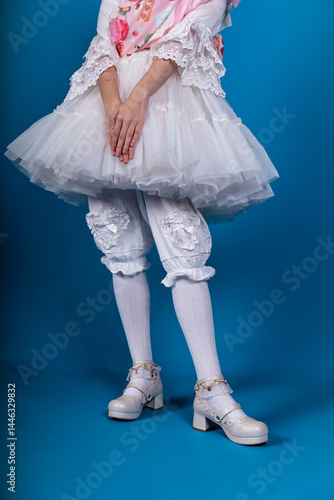 фотографія Cosplayer wearing kawaii outfit and platform shoes posing on blue background