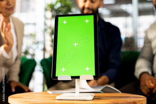Focus on isolated screen tablet used by employees in blurry background preparing for business meeting. Close up of chroma key device used by people doing research analysis for startup organization