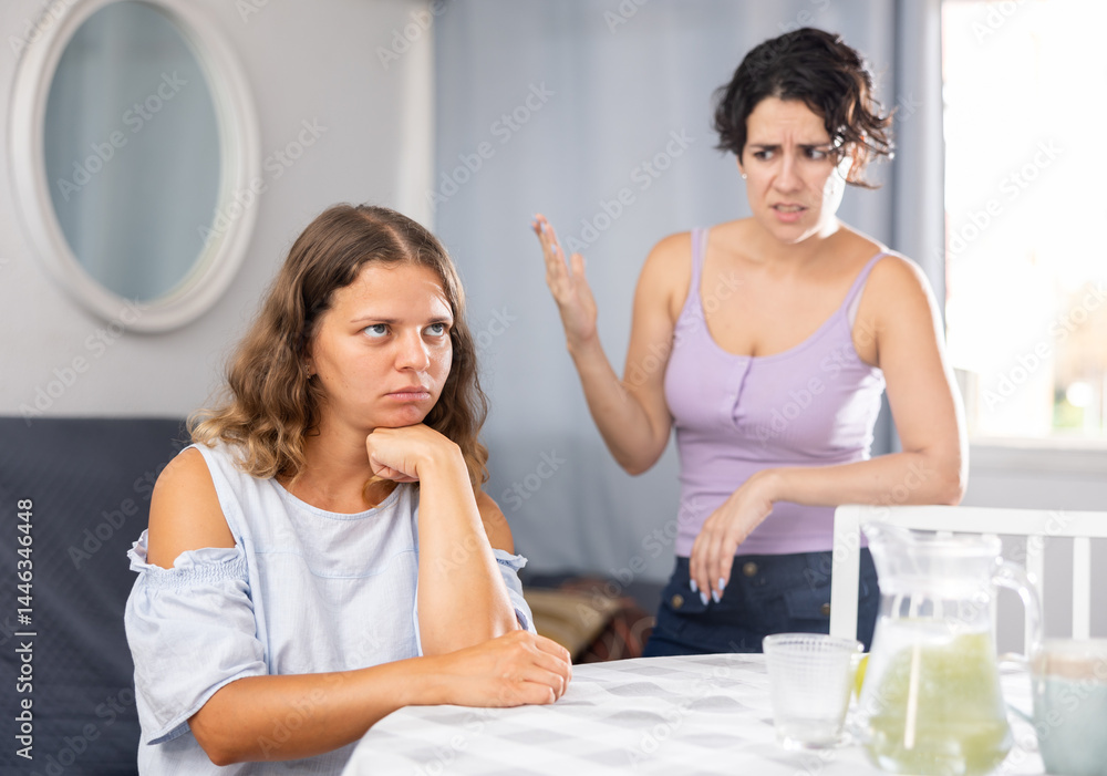 Young bored woman ignoring her female partner yelling aggressively with wrathful expression, LGBTQ family problems Young bored woman ignoring her female partner yelling aggressively with wrathful expression, LGBTQ family problems