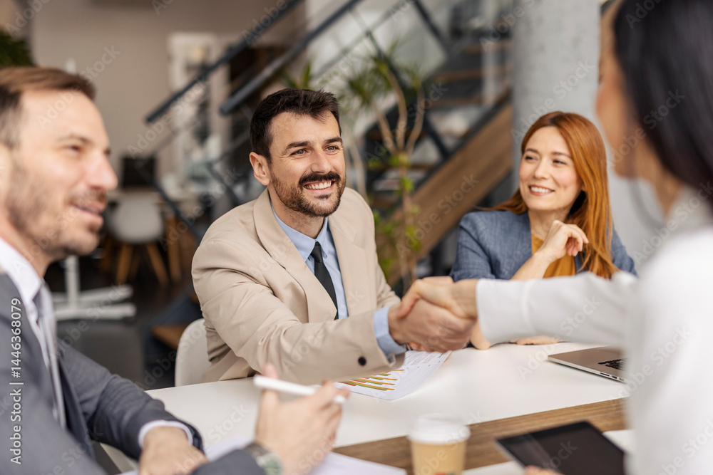 Businessman shaking hands with business partner and closing a deal on a meeting at boardroom. Businessman shaking hands with business partner and closing a deal on a meeting at boardroom.