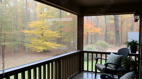 Cozy screened porch in early morning, rain drops on window and autumn leaves and woods in the background.