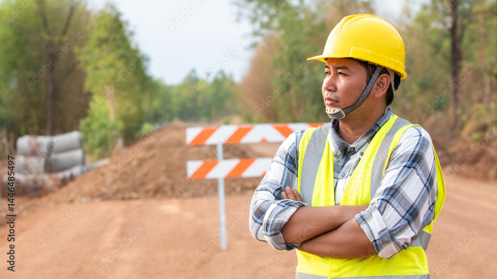 Road Construction Supervision: A determined construction worker with a yellow safety helmet and reflective vest stands vigilantly.