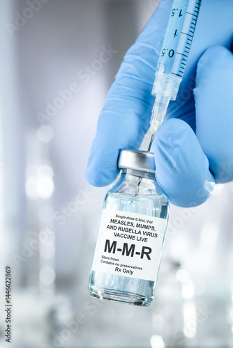 Bild auf Leinwand Healthcare concept with a hand in blue medical gloves holding MMR, measles mumps
