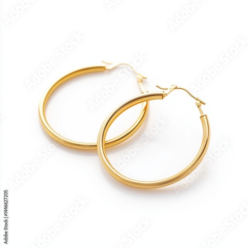 Obraz na płótnie Elegant gold hoop earrings displayed on a white background highlighting their sleek design and shiny finish. w salonie