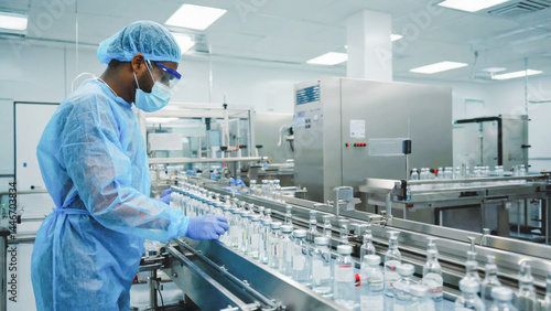 High-tech pharmaceutical laboratory, close-up of a scientist in full PPE using precision instruments to measure active compounds, sterile and futuristic environment.