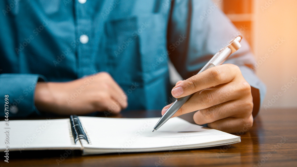 Male hand taking notes on the notepad. businessman working at work table, checklist writing planning investigate enthusiastic concept. focus on man hand holding pen, putting signature at official pape Male hand taking notes on the notepad. businessman working at work table, checklist writing planning investigate enthusiastic concept. focus on man hand holding pen, putting signature at official pape