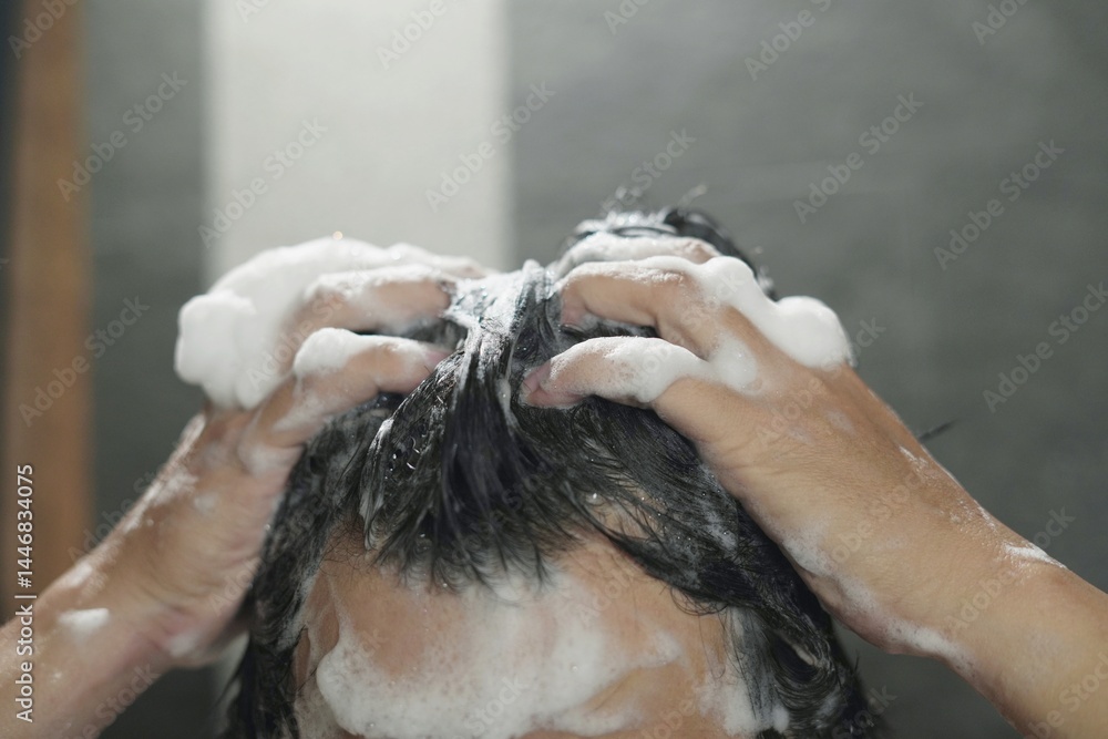 Naklejka premium man bathing wash his hair with shampoo in shower. for hygiene. Liquid drops, and foam wash for texture and cleaning routine.