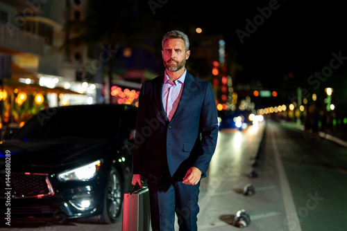 Wallpaper Mural Businessman walking at night city. Rich man in suit walk through city. Businessman near luxury car. Businessman walking near night city lights. Business style. Wealthy businessman in luxury setting. Torontodigital.ca