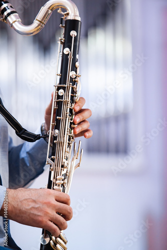A fragment of a bass clarinet in the hands of a musician