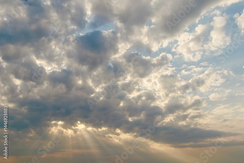 Photography Sunlight streams through a moody sky filled with dark and light clouds, creating a dramatic and atmospheric natural scene