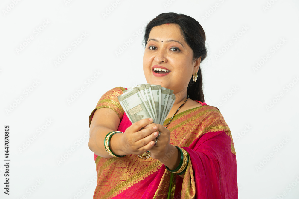 Indian Happy traditional woman showing Indian currency notes on white Indian Happy traditional woman showing Indian currency notes on white