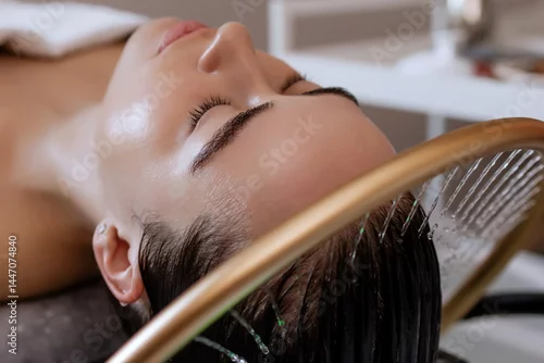 Fototapeta na wymiar Close-up of a woman receiving a head massage during a Japanese head spa treatment with water flowing from a special hair washing tool, focusing on the scalp relaxation and beauty therapy