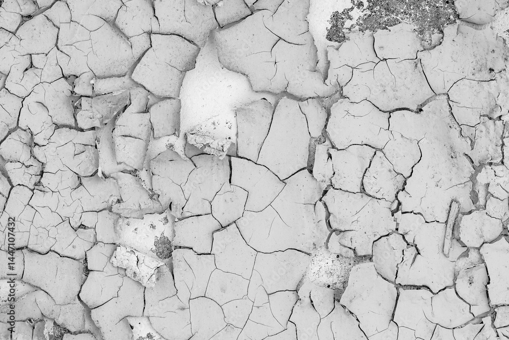 Peeling paint on the wall. Old concrete wall with cracked flaking paint. Weathered rough painted surface with patterns of cracks and peeling. High resolution texture for background and design. Closeup