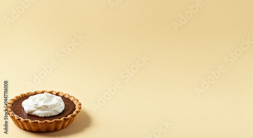 Minimalist Chocolate Tart with Cream Topping on Beige Background with copy space