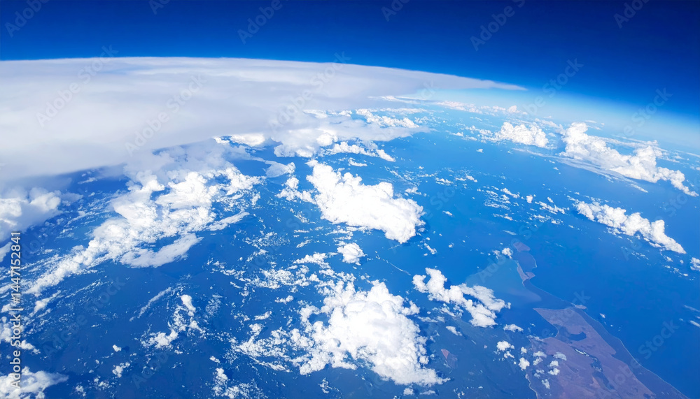 Fototapeta premium breathtaking view of Earth from above, showcasing vibrant blue atmosphere, fluffy white clouds, and diverse landforms. scene evokes sense of wonder and tranquility as it captures beauty of our