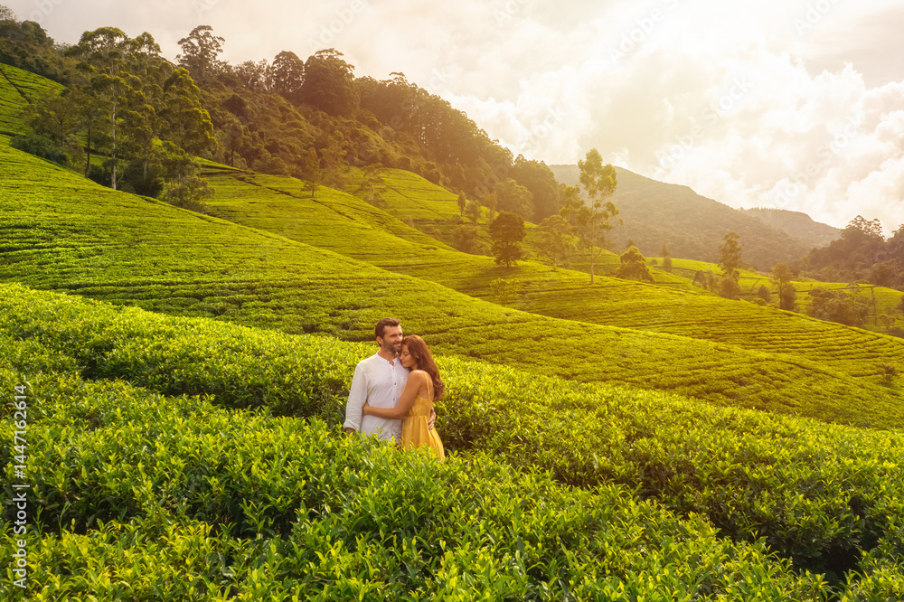 A couple embraces in a lush tea plantation in Nuwara Eliya, Sri Lanka, as the golden hour light bathes the landscape in a warm glow. This serene moment is perfect for travel and romance-themed
