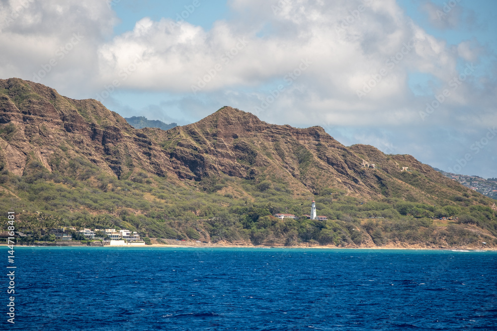Fototapeta premium Close view of Diamond Head’s rugged crater face with forested slope and beach below, captured March 15, 2019 in Honolulu, Hawaii, USA