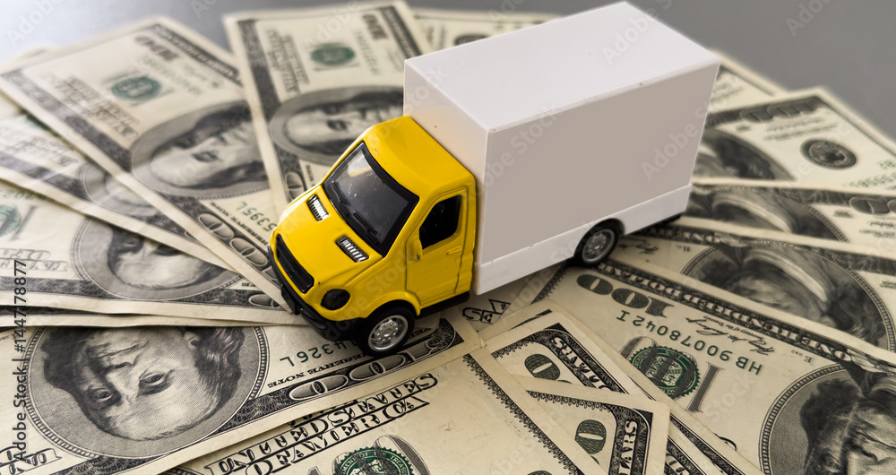 White toy truck lie on dollars, space for text.