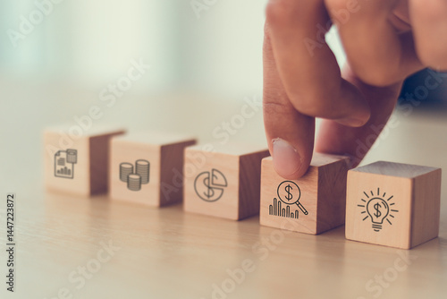 Financial Management and Business Planning Concept. Wooden blocks with icons representing financial management, including budgeting, investment, analysis and growth strategy, using technology.