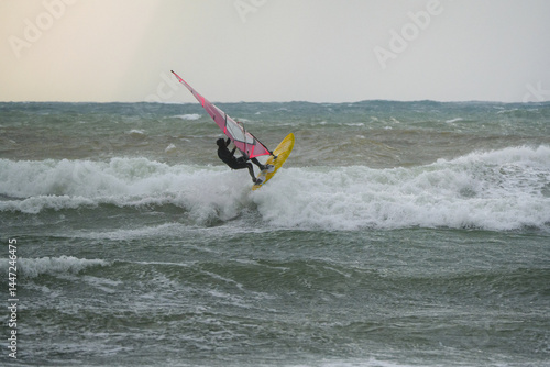Photos Water Sport Activity - Windsurfer Riding a Wave in Rough Sea on a Windy Day