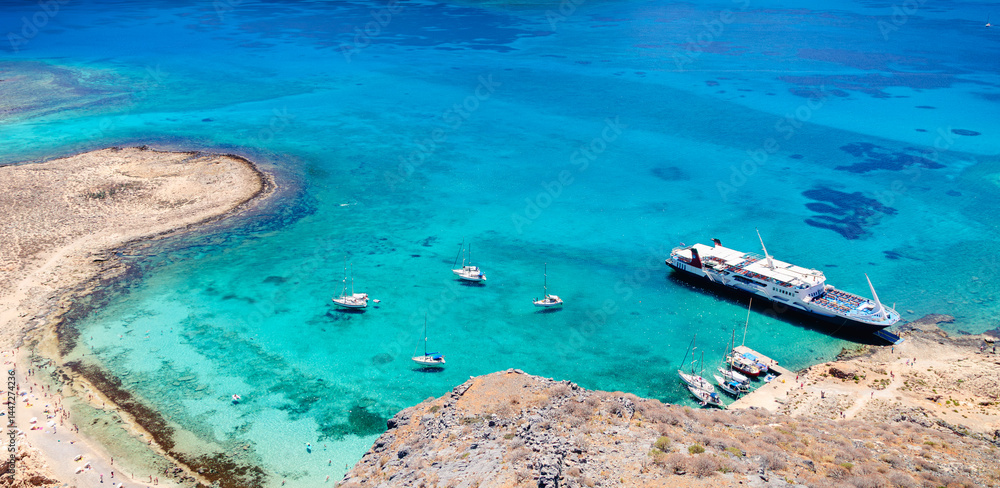 Sailboats anchored near a stunning turquoise beach