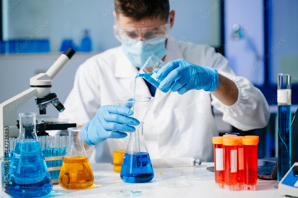 Scientist mixing chemical liquids in the chemistry lab. Researcher working in the laboratory Scientist mixing chemical liquids in the chemistry lab. Researcher working in the laboratory