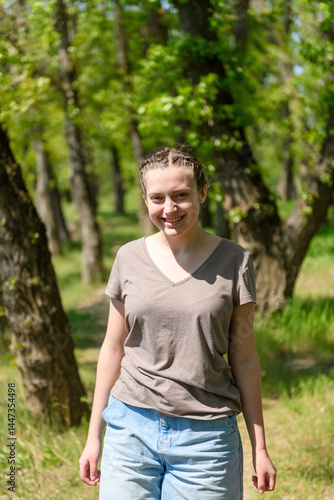 Teen girl a girl walks along a forest path, beautiful spring nature, green leaves, landscape