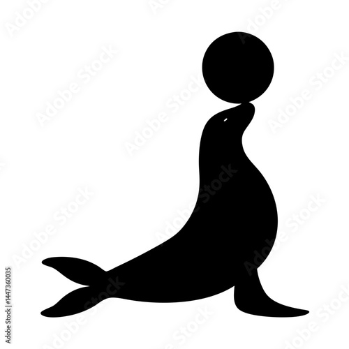 Silhouette of a talented sea lion balancing a ball on its nose