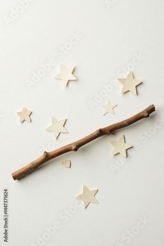 A simple branch and off-white star shapes arranged on a light background