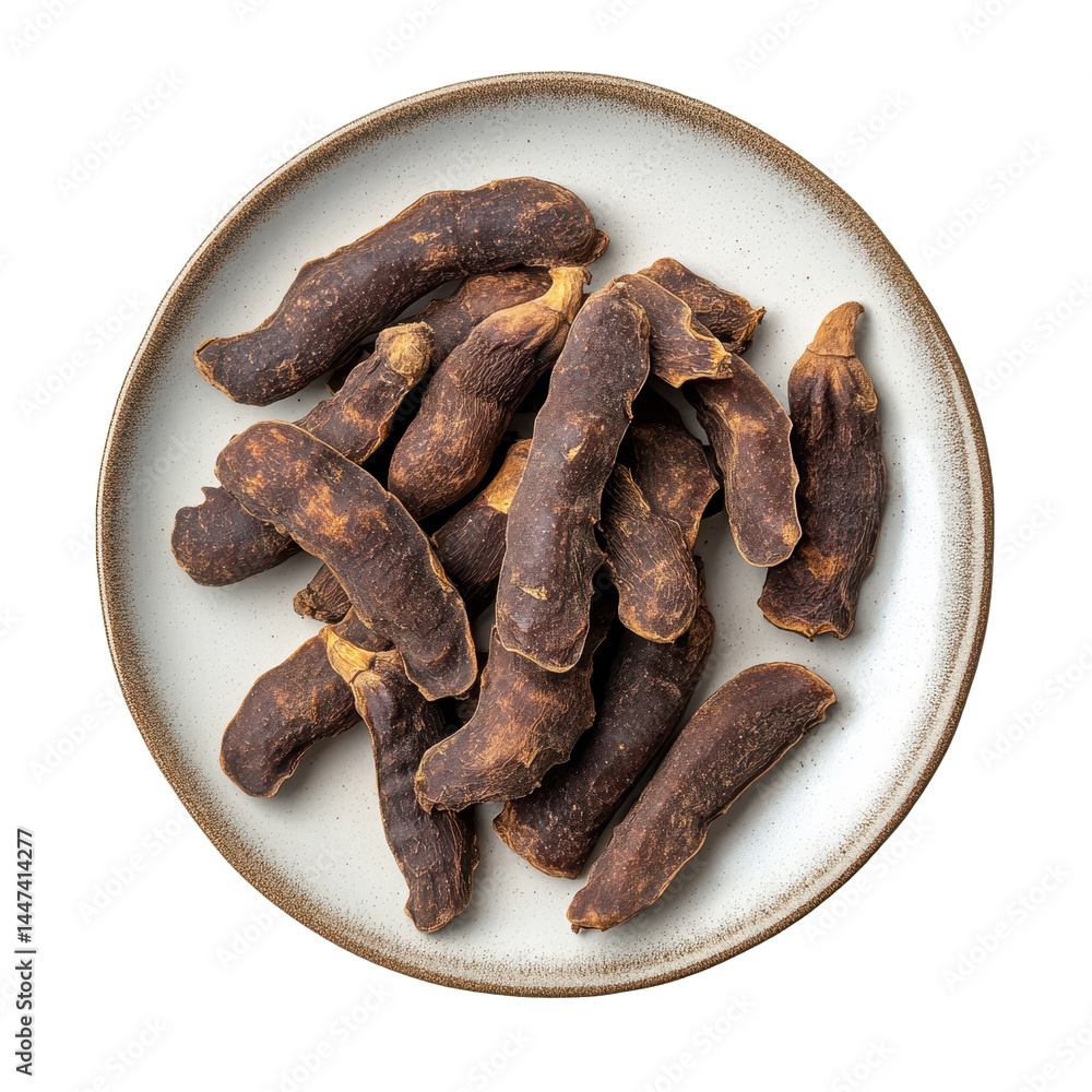 Dried Tamarind pods arranged on a ceramic plate, showcasing their rich, dark brown exterior with a textured surface Dried Tamarind pods arranged on a ceramic plate, showcasing their rich, dark brown exterior with a textured surface
