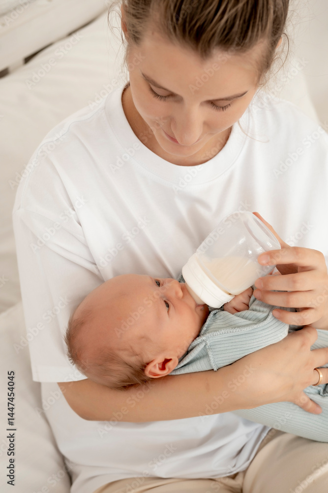feeding a baby from a bottle, a mother feeds a newborn baby with milk while holding it in her arms, baby food, a baby sucks a bottle feeding a baby from a bottle, a mother feeds a newborn baby with milk while holding it in her arms, baby food, a baby sucks a bottle