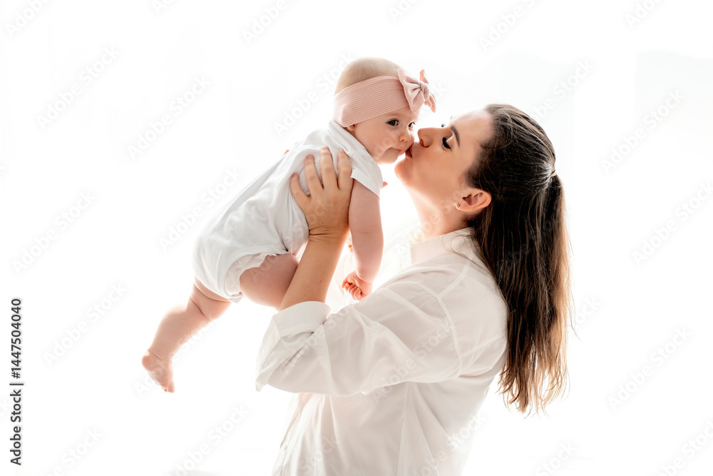 mom and baby hug and kiss at home on the bed in the bedroom, parental love and care, happy motherhood, mom with a baby in her arms, space for text mom and baby hug and kiss at home on the bed in the bedroom, parental love and care, happy motherhood, mom with a baby in her arms, space for text