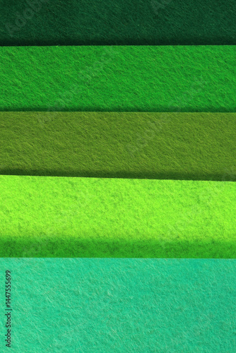 Different shades of green felt folded horizontally on top of each other. From dark green to light green.