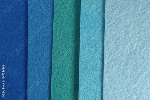 Different shades of blue felt folded vertically on top of each other. From dark blue to light blue.