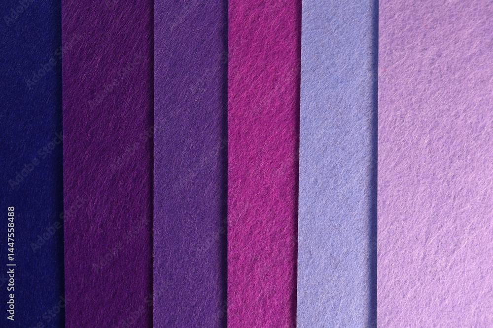 Fototapeta premium Different shades of purple felt folded vertically on top of each other. Dark and light purple felt color palette.