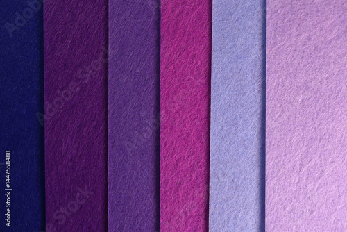 Different shades of purple felt folded vertically on top of each other. Dark and light purple felt color palette.