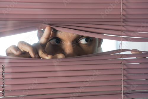 Obraz na plátně Curious businessman looking through venetian blinds spying on someone