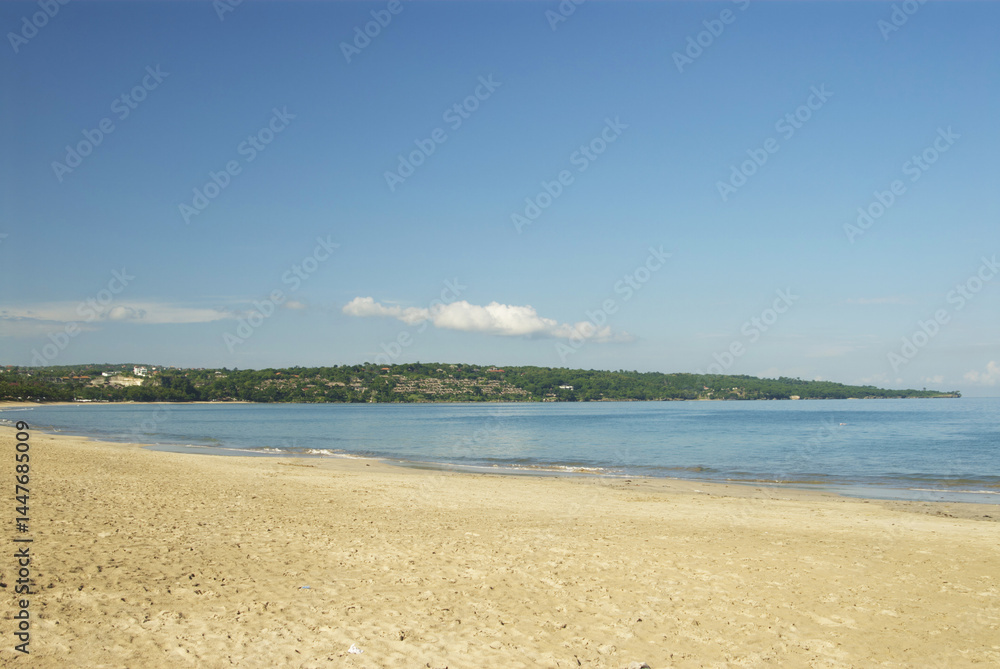 Fototapeta premium Tranquil coastal landscape of bali beach with clear blue sea and sky