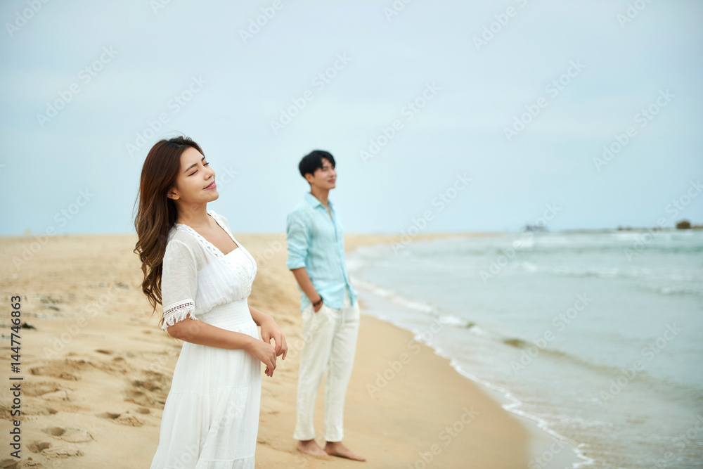 Woman and Man on Beach in White Dress and Blue Shirt Woman and Man on Beach in White Dress and Blue Shirt