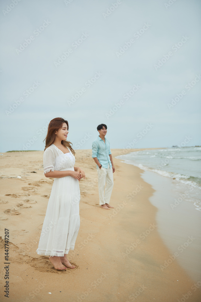 Woman and Man on Beach in White Dress and Blue Shirt Woman and Man on Beach in White Dress and Blue Shirt