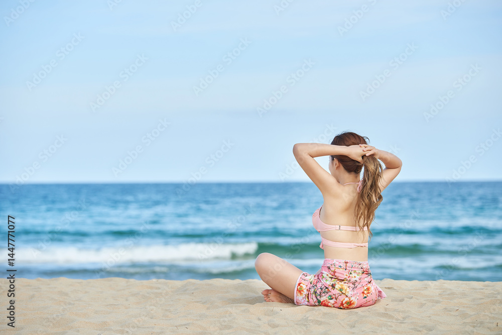 Young Woman Sitting on Beach Looking at the Ocean Young Woman Sitting on Beach Looking at the Ocean