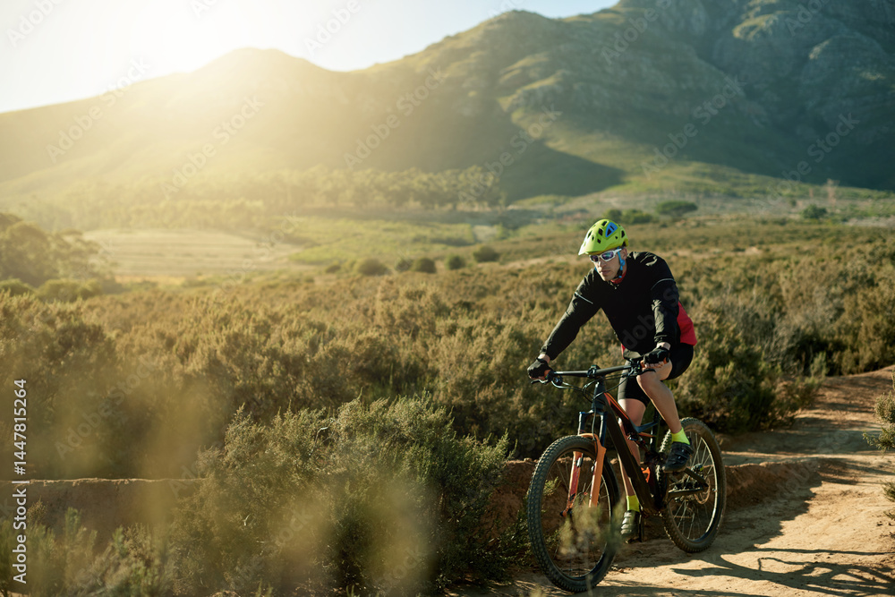Naklejka premium Man, cyclist and mountain bike with dirt road for cardio workout, outdoor adventure or extreme sport in nature. Male person, bicycle and cycling with helmet for adrenaline on path or natural trail