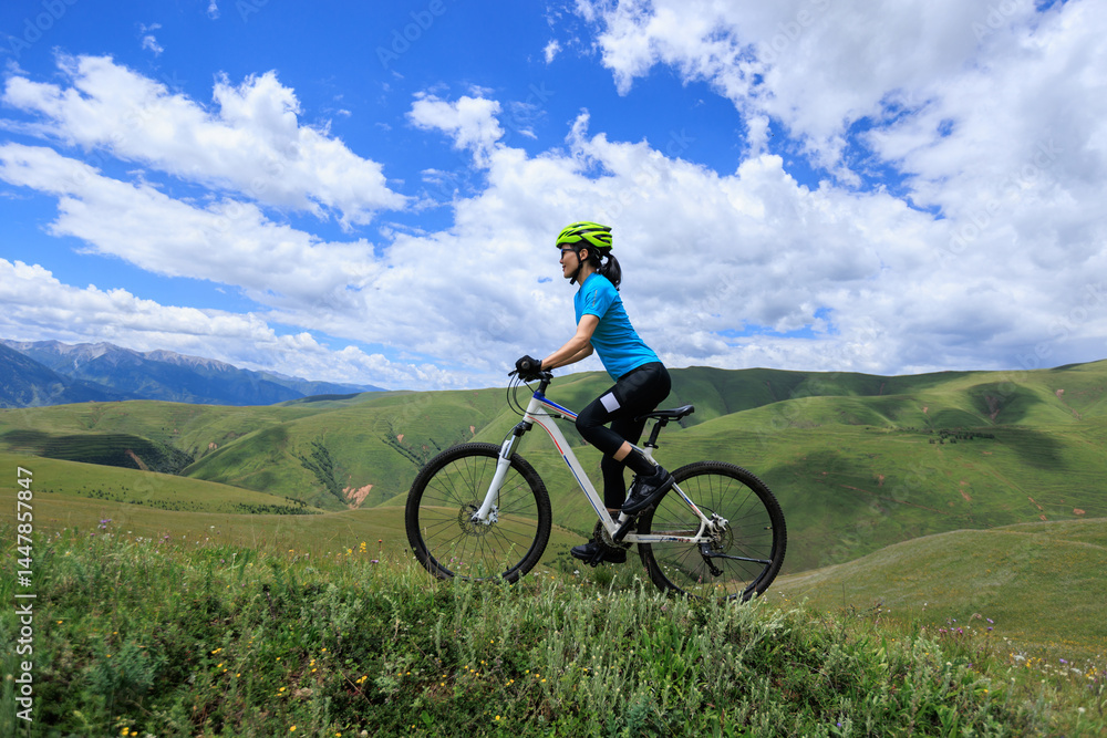 Asian woman riding a mountain bike down hill on beautiful mountain top Asian woman riding a mountain bike down hill on beautiful mountain top