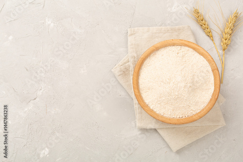 Tableau sur toile Bowl with spelt flour on concrete background, top view