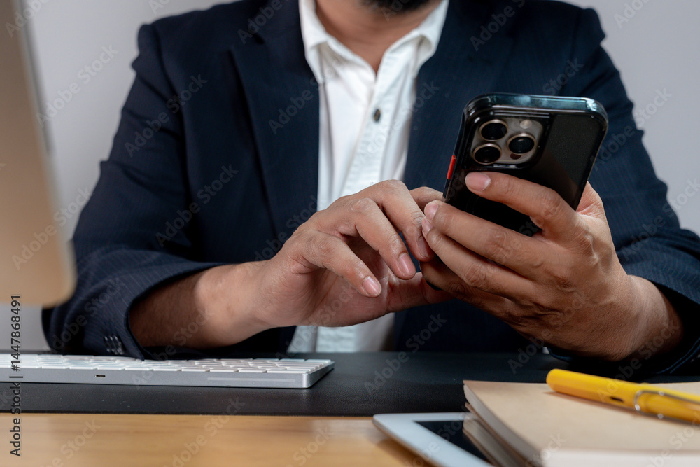 Fototapeta premium Cropped image of a businessman holding a smartphone