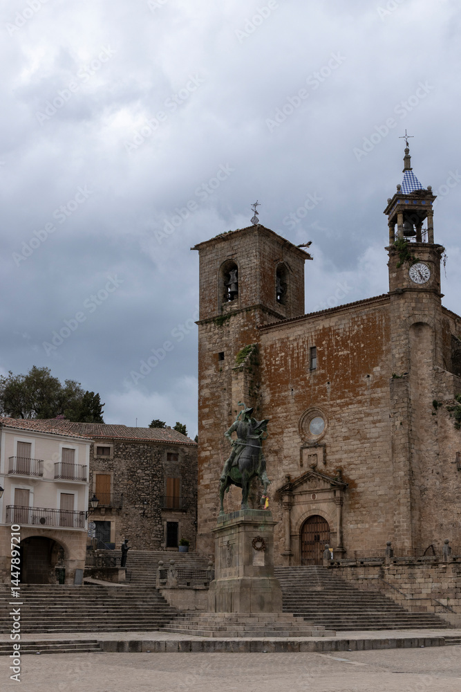 Fototapeta premium Equestrian statue dominating square in front of church in pals, spain